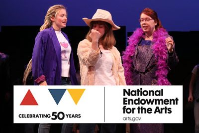 Three actors stand on stage with National Endowment for the Arts logo