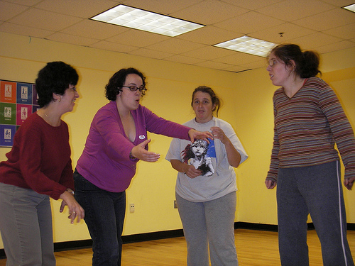 Emilia showing a dance move to three actors