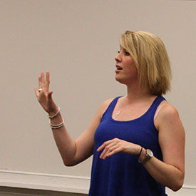 Elizabeth Cronin, a blonde woman in blue tank top speaking