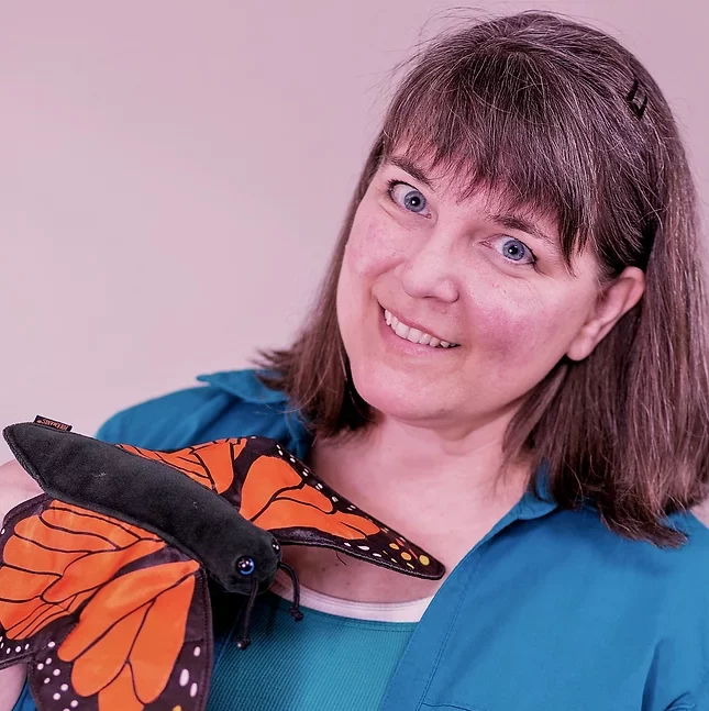 Headshot of Penny Russell smiling with a butterfly puppet in hand