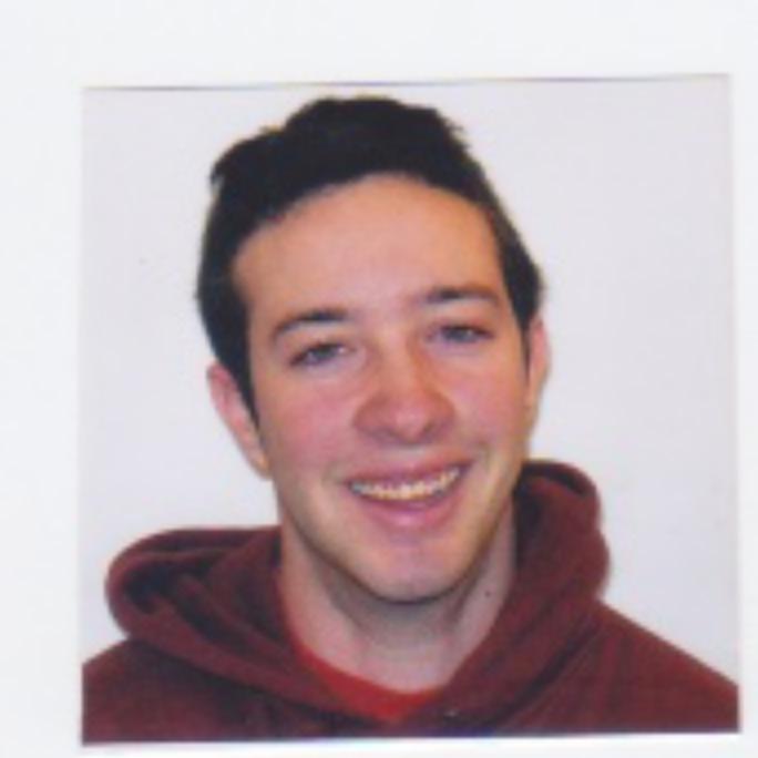 Headshot of a smiling man in a maroon hoodie.