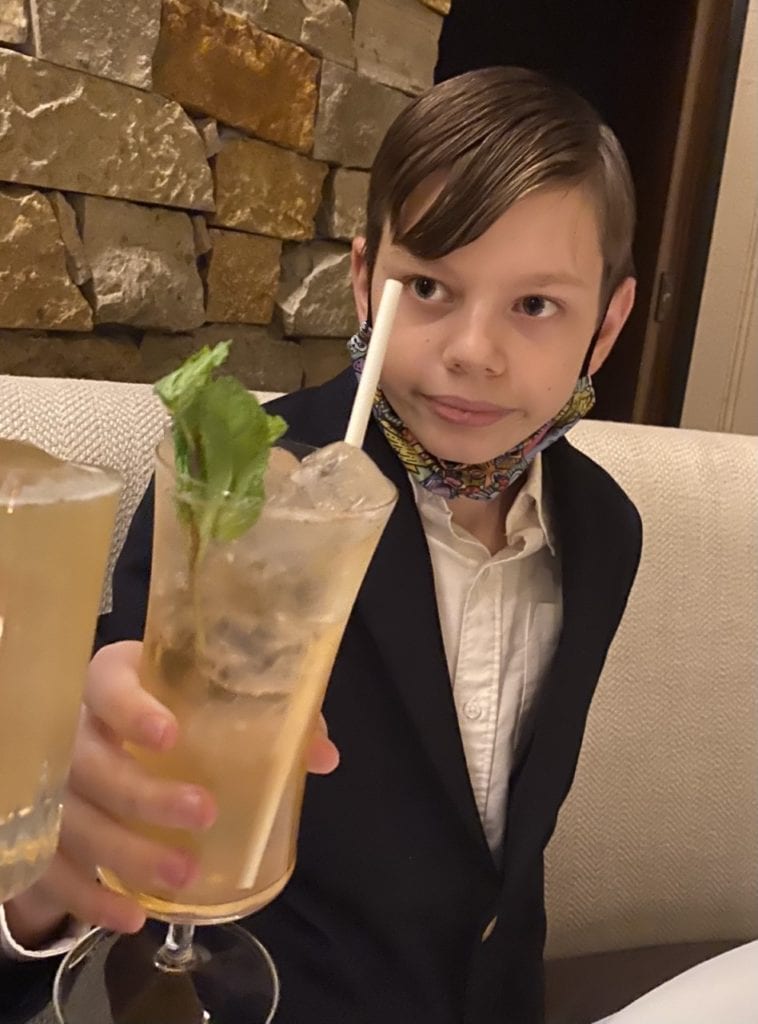 Shaun Stronach in a suit holding a mocktail